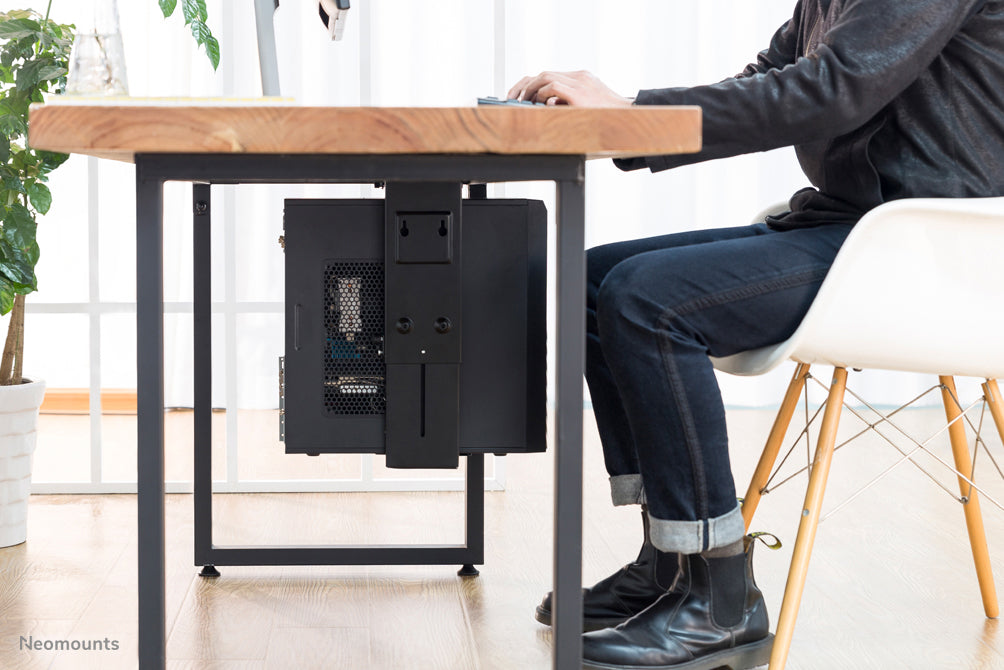 Neomounts NM-CPU100 schwaarz ass eng Halterung, mat där Dir e PC oder Thin Client un de Schreifdësch fixéiert.