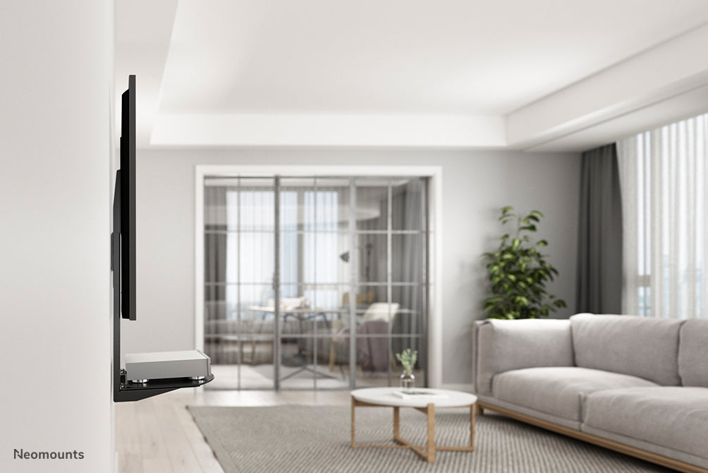 Neomounts AV-Halterung, Modell NS-SHELF100, ass ideal fir AV-Geräter ënner Flat-Screen-Halterungen ze placéieren.